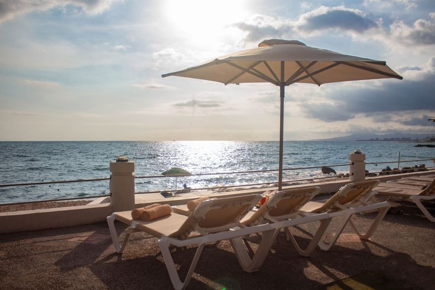 Close-up of sun loungers with umbrella near the beach at Plaza Pelicanos Club Beach Resort