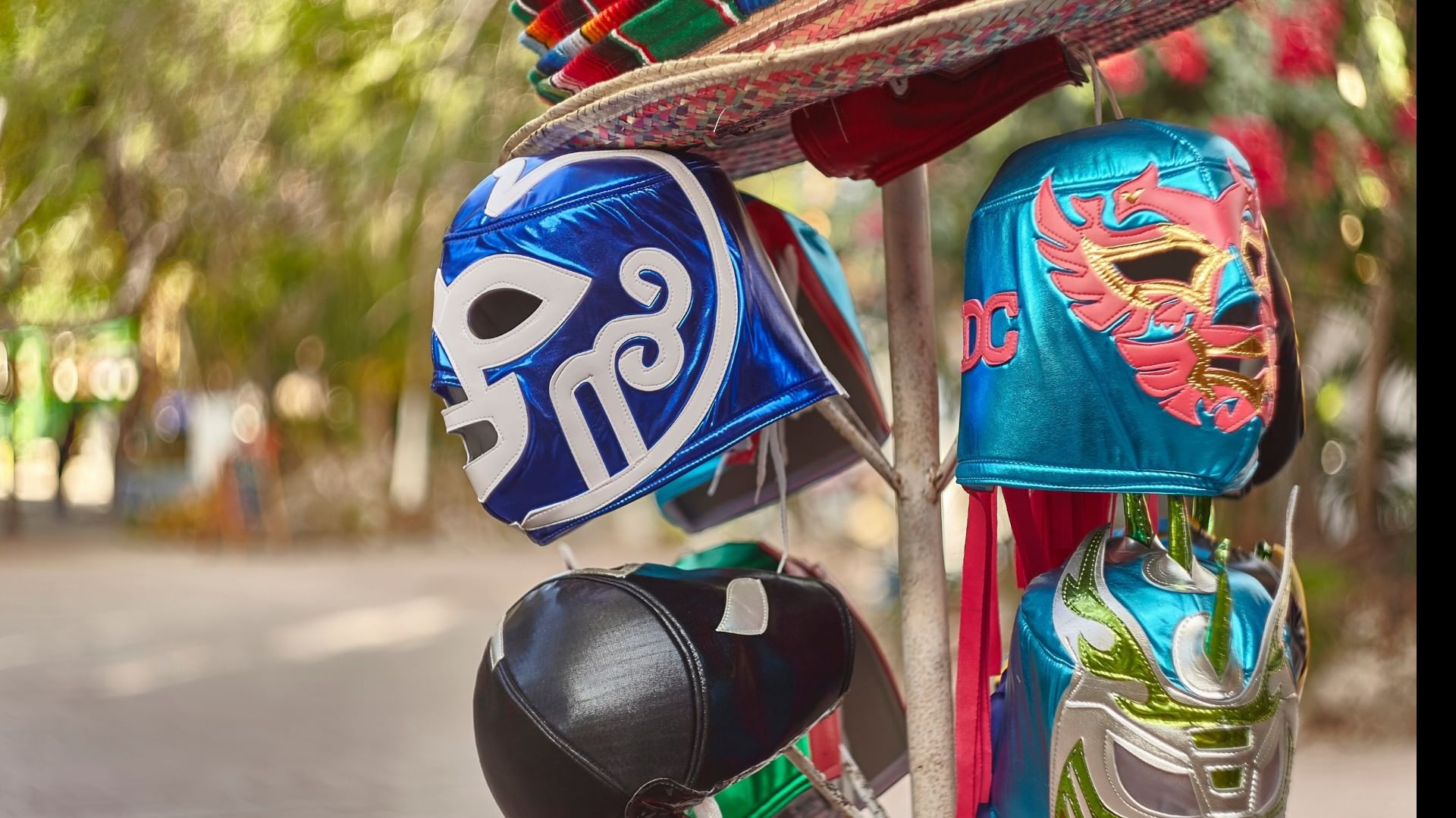 Vibrant Lucha Libre wrestling masks and sombreros displayed at a local market near the Real Inn Tijuana