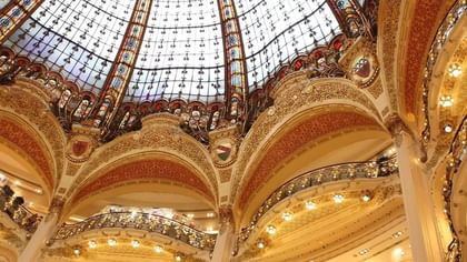 Galeries Lafayette by gold balconies under intricate architectural details near Warwick Paris Champs Elysées
