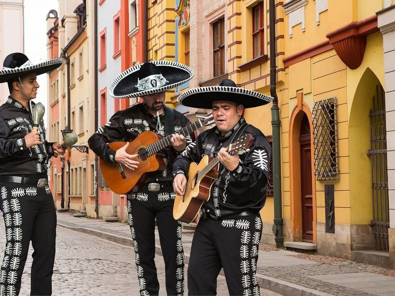 3 musicians performing on a street near Grand Fiesta Americana