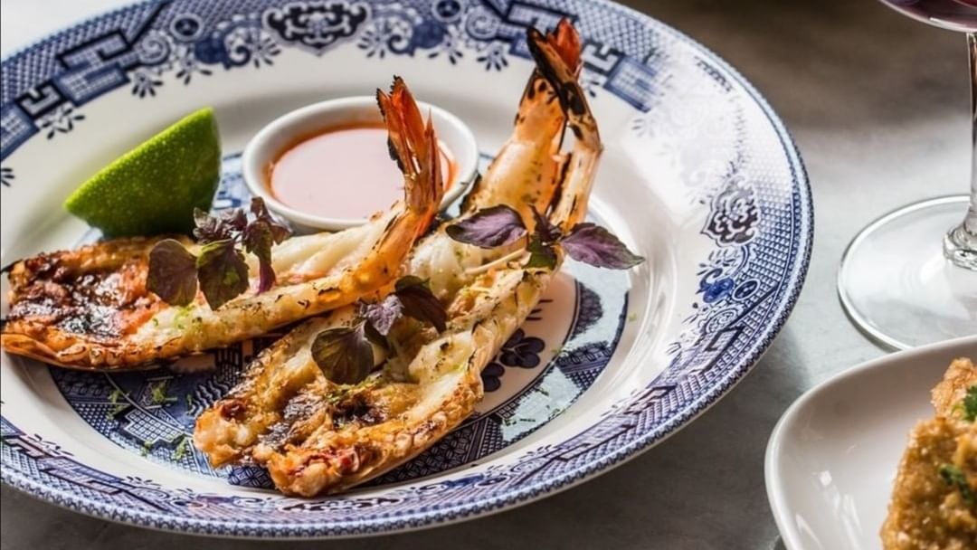 Gourmet grilled king prawns served with fresh lime and sauce on patterned china in Yok Thai at Elysium Manly