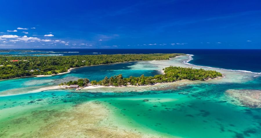 Aerial view of tropical islands and clear blue waters with lush greenery at Warwick Le Lagon - Vanuatu.
