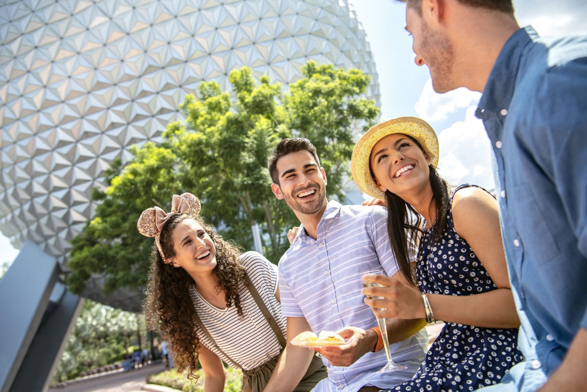 Group of friends enjoying snacks in front of a geodesic sphere near Lake Buena Vista Resort Village & Spa