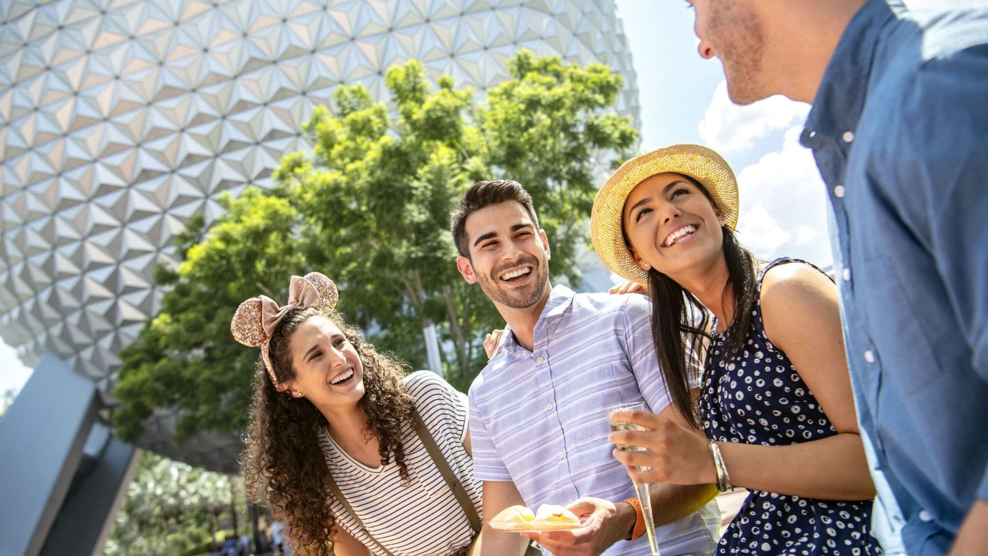 Group of friends enjoying snacks in front of a geodesic sphere near Lake Buena Vista Resort Village & Spa