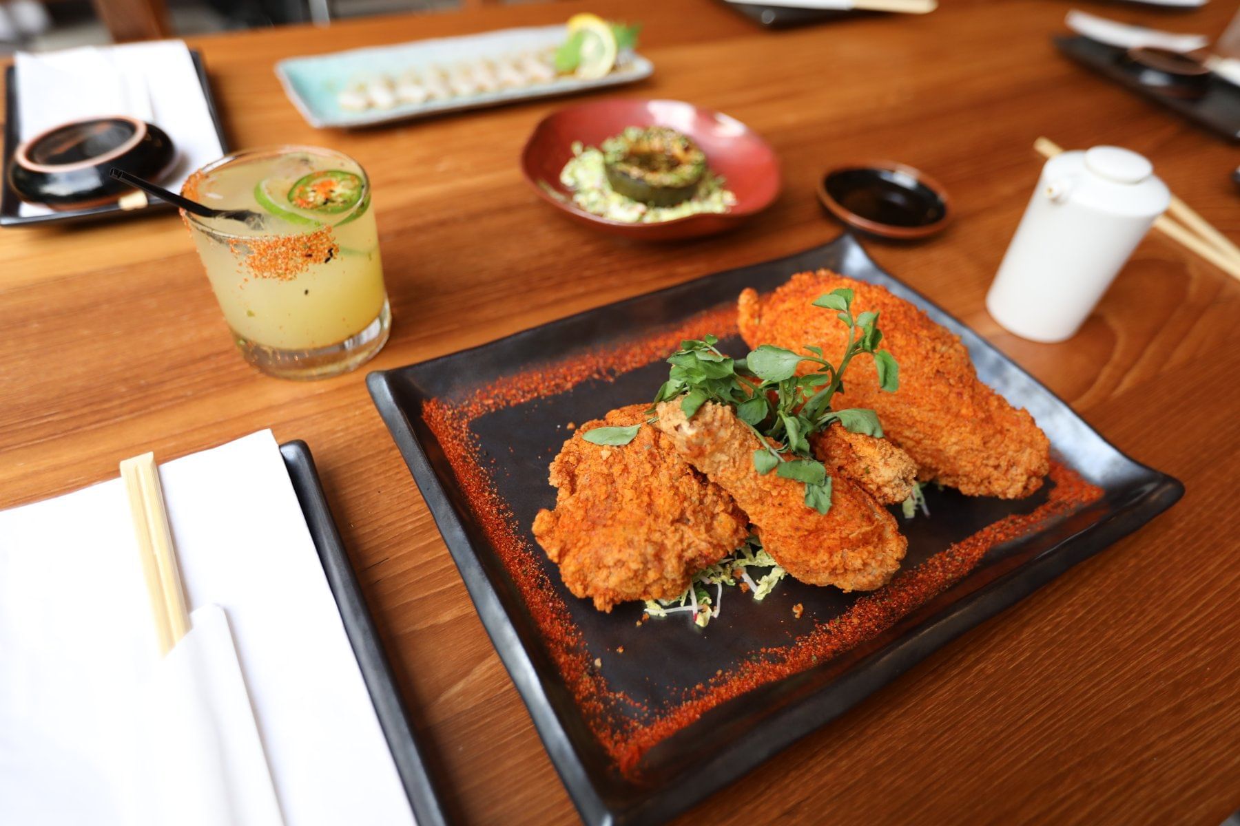 A plate of fried chicken and a drink on a wooden table