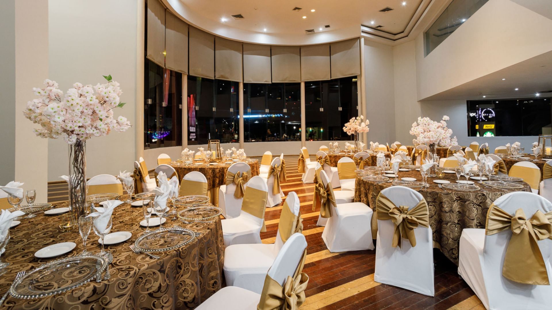 Elegantly decorated event room with round tables and floral centerpieces at Real Inn Tijuana