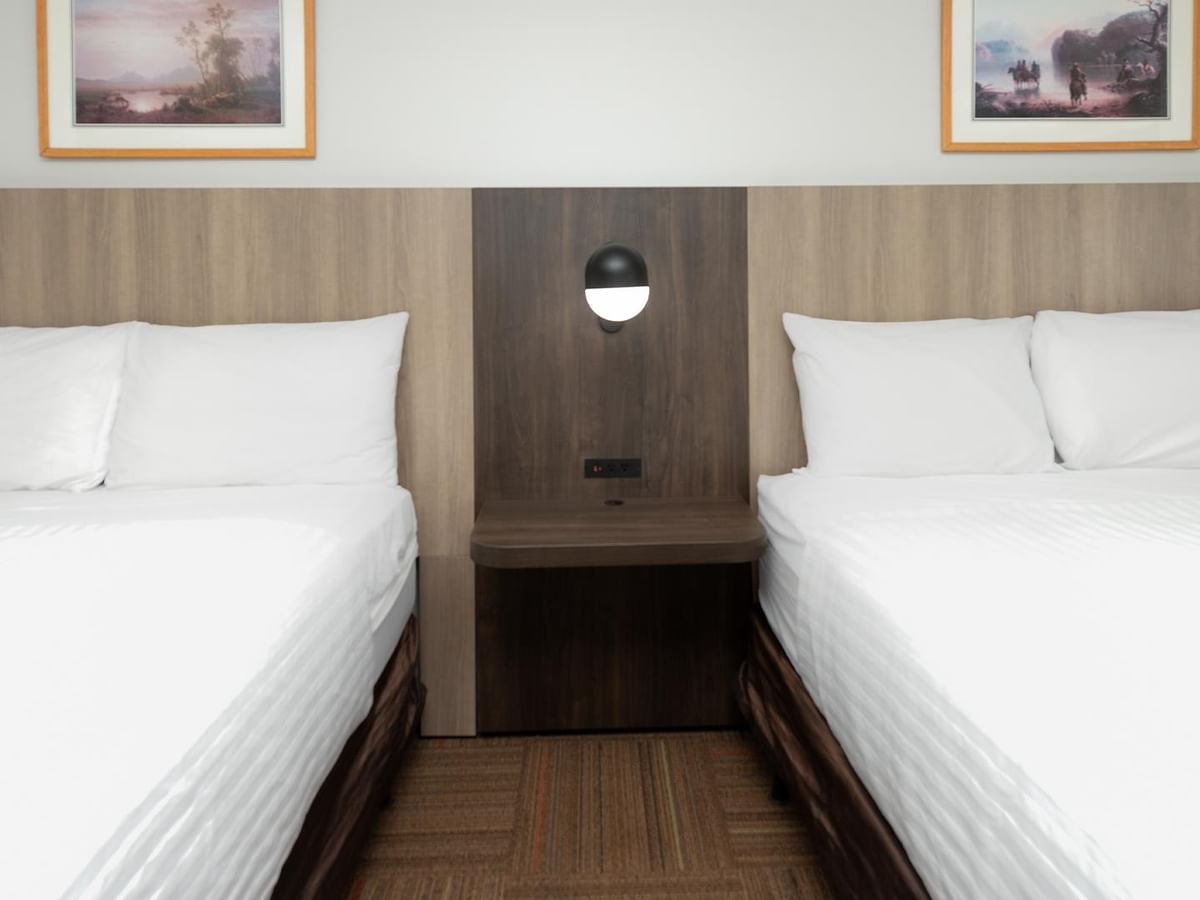 Coast Two Queens room with two queen beds, wood headboard and framed artwork.