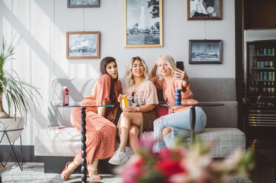 3 ladies taking a selfie on a couch at Hotel Angeleno