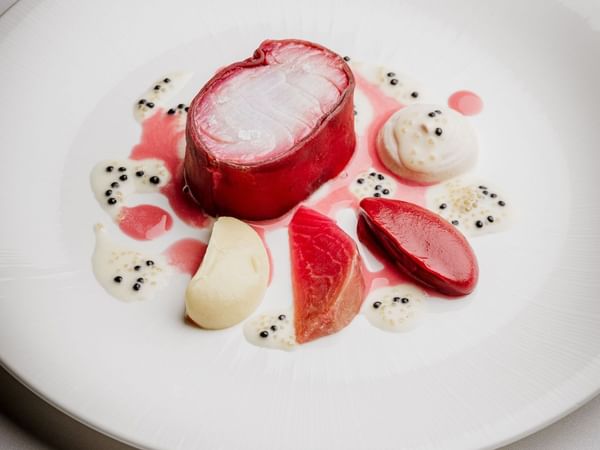 Exquisitely plated dish with a centerpiece of cured meat, sauces, and garnishes at The Capital Hotel, London.
