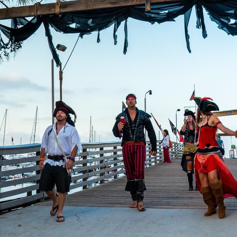 A group of people in pirate costumes walking on a pier at Catalina Island Company