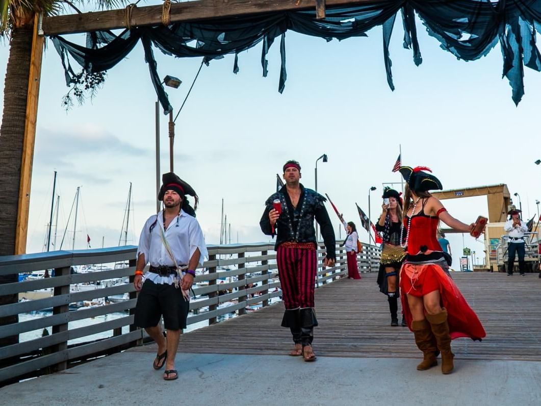 A group of people in pirate costumes walking on a pier at Catalina Island Company
