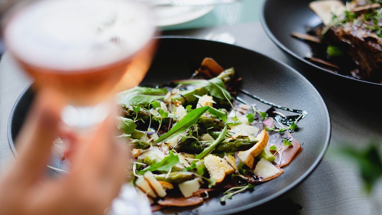 A person enjoying a Truffle salad with wine at Pullman Cairns