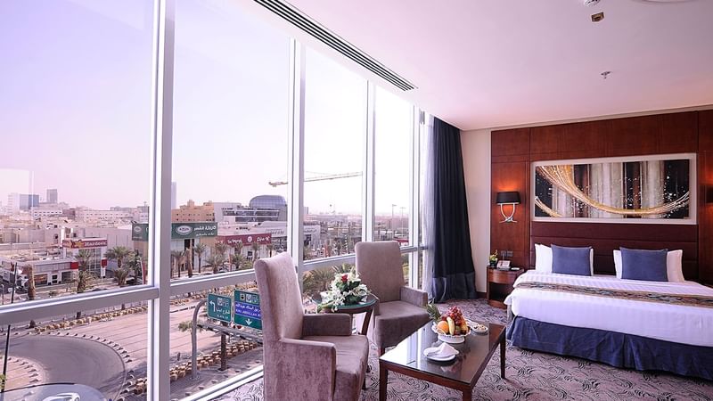 Bed & lounge area with a city view in Junior Suite at Al Hamra Palace by Warwick Riyadhd
