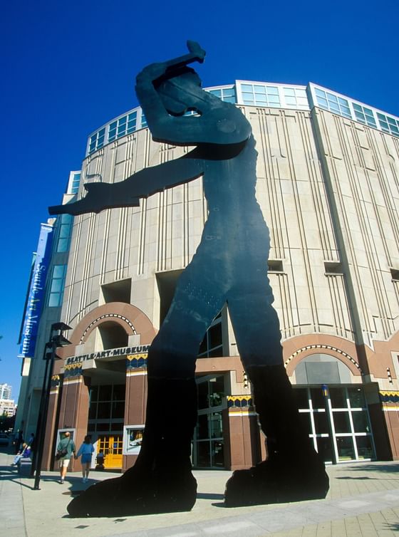 The Hammering Man statue by the Seattle Art Museum under a clear blue sky near Paramount Hotel Seattle