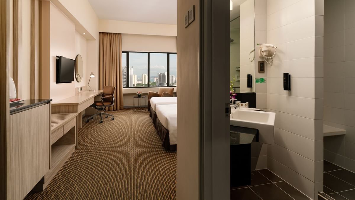 Wall-mounted TV and work desk facing the beds in Executive Twin Room at Sunway Hotel Georgetown