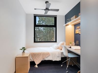 Bedroom with desk, chair, bed, and window at La Trobe University - North and South Apartments.