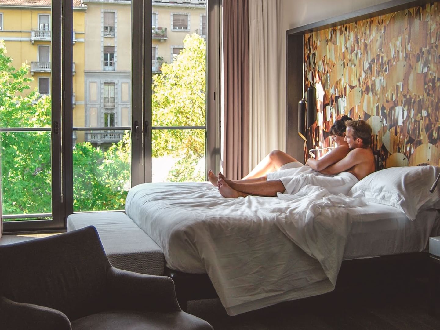 Couple laying on a bed in a room at Duparc Contemporary Suites