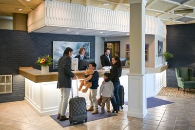 Family checking in at the front desk of Rodd Grand Yarmouth, receiving a warm welcome from the lobby staff
