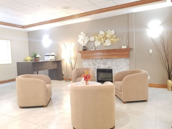 White themed lobby area arranged with arm chairs at Fort McMurray Hotel