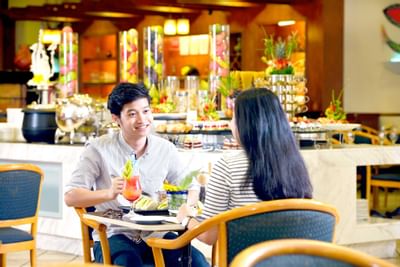 A couple savoring freshly prepared food and drinks at Aqua Coffee - Lexis Port Dickson