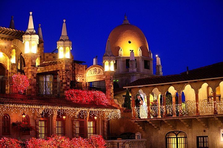 exterior of Mission Inn Hotel with bride and groom posing for pi
