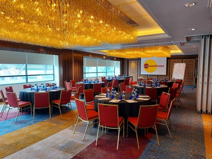 Breakout Rooms with set-up banquets under the elegant chandelier and facing a large screen at One World Hotel