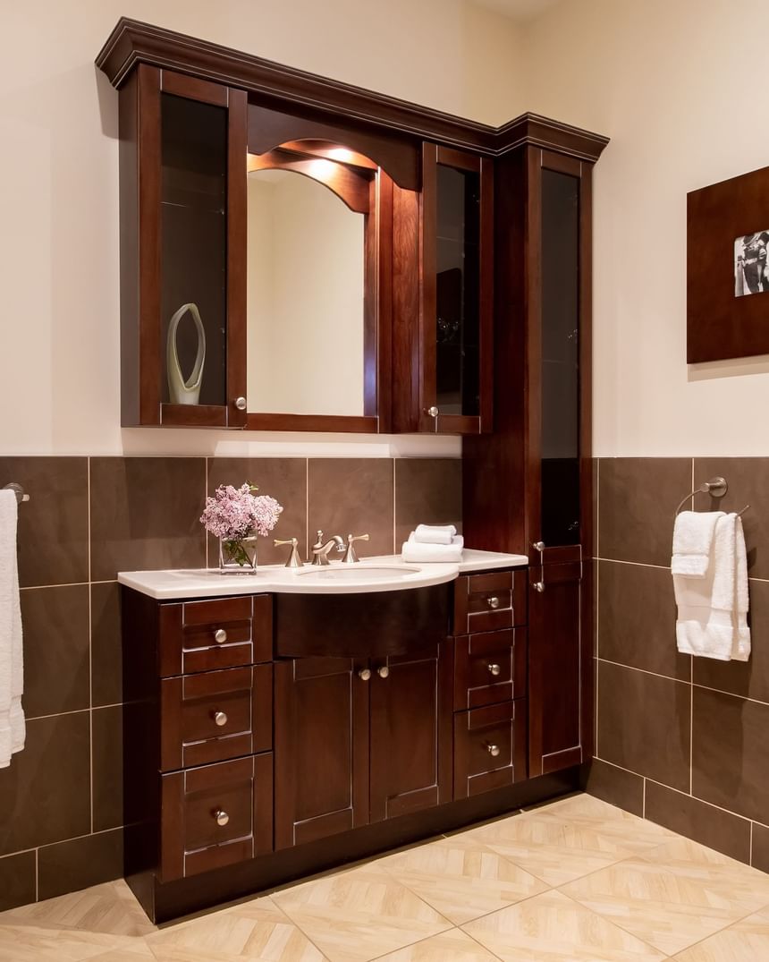 bathroom with built in wooden cabinet with sink and mirror