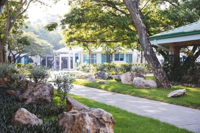 Walkway surrounded by rocks and trees at Cha Cha Hotel
