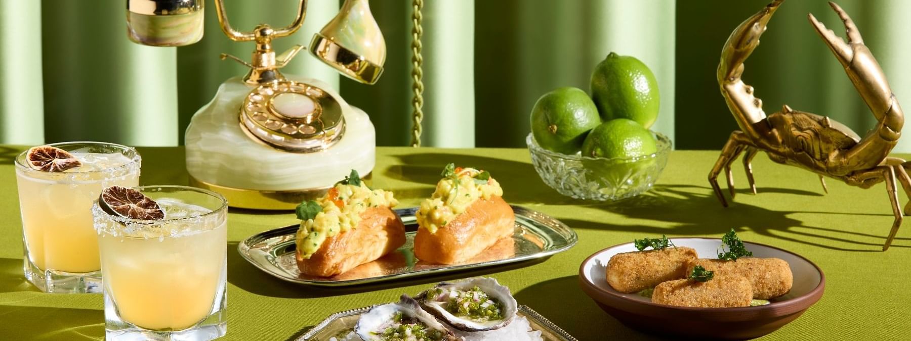 Food and drinks with a vintage phone served on a green tablecloth in Fidels Bar & Restaurant at Crown Hotel Melbourne