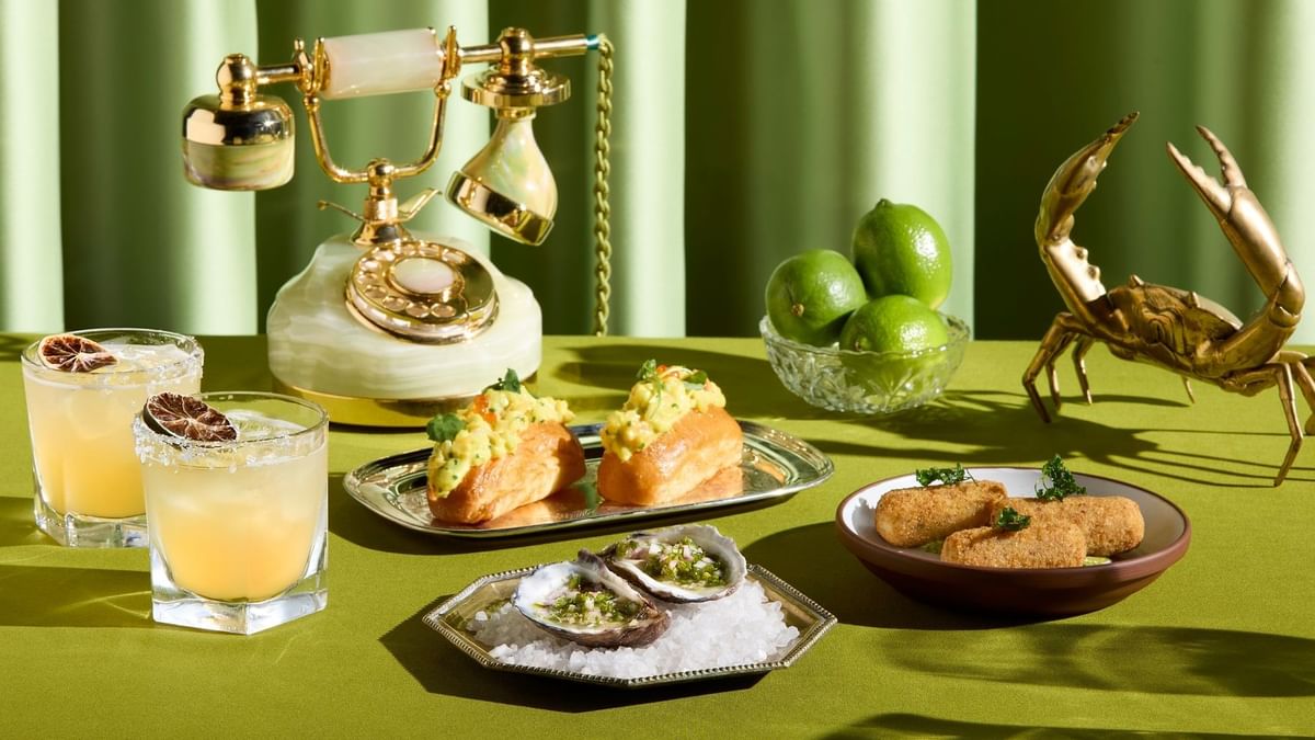 Food and drinks with a vintage phone served on a green tablecloth in Fidels Bar & Restaurant at Crown Hotel Melbourne