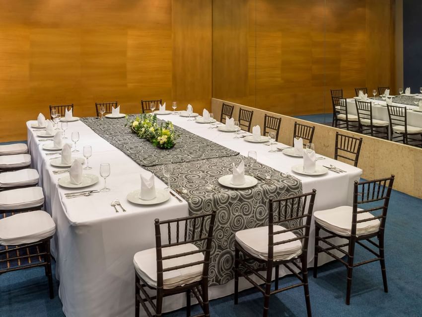 Elegant table settings include white napkins, plates, and wine glasses in the Barcelona Venue at Real Inn San Luis Potosi