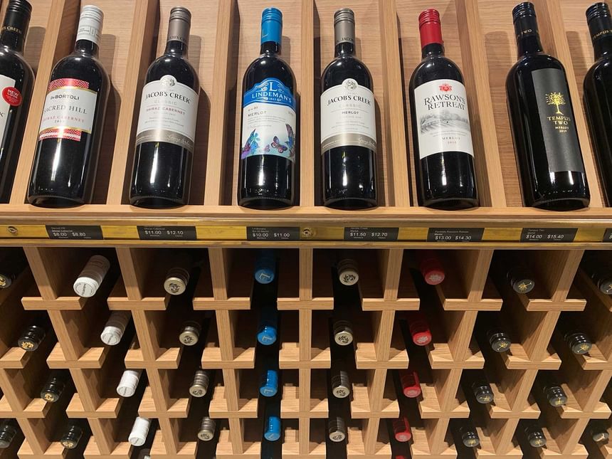 A wooden rack with various wine bottles at Encore by Mingara