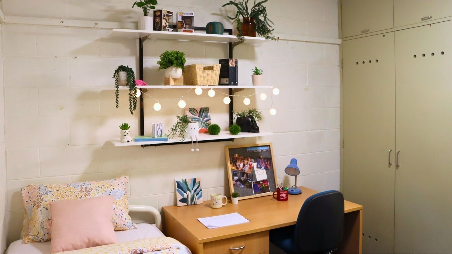 A neatly organized dorm room at La Trobe University with desk, shelves, and bed.