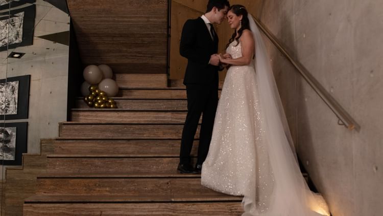 Couple stands on a staircase, exchanging vows, surrounded by elegant decor at Live Aqua