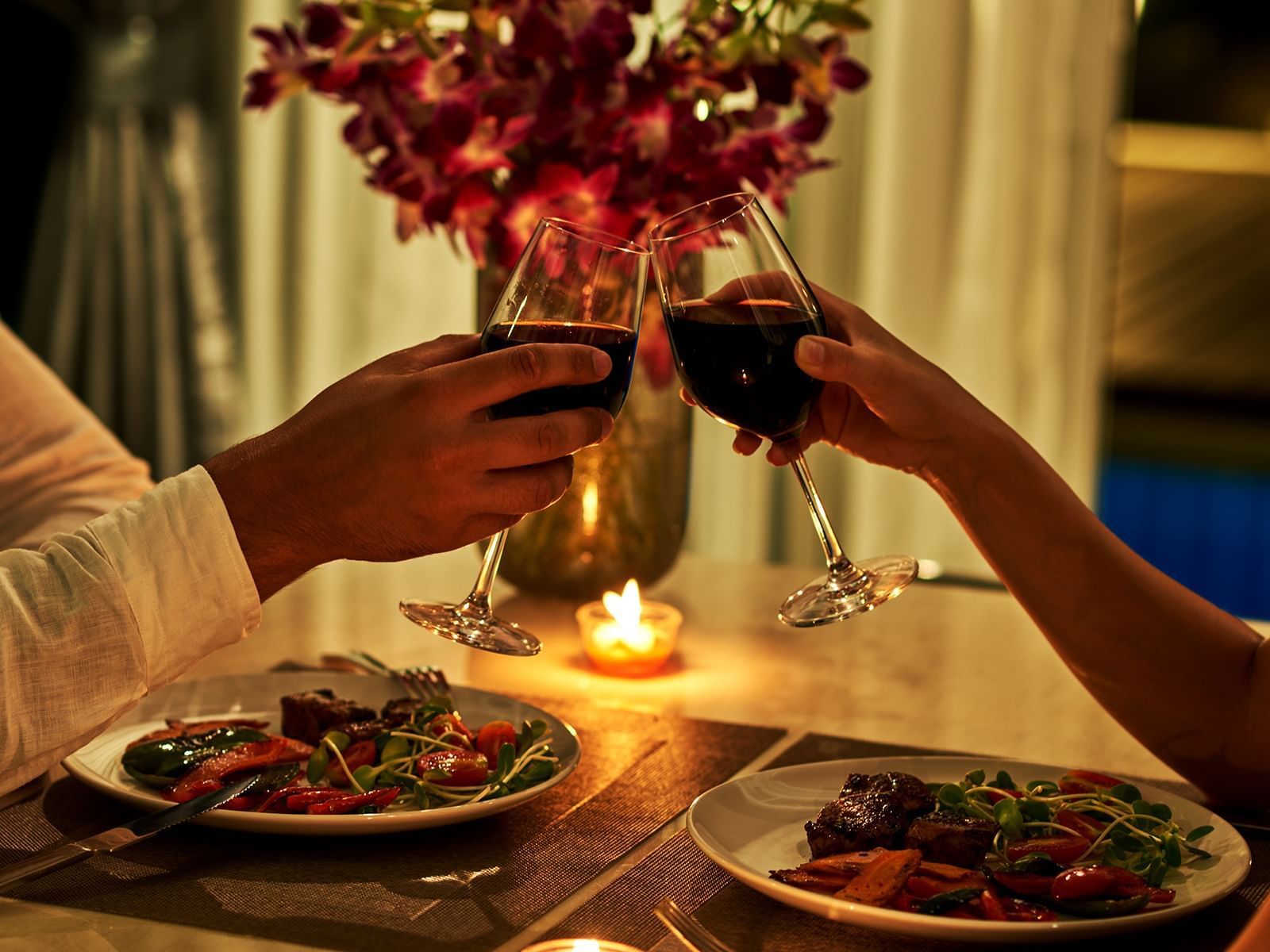 Couple toasting wine in romantic dinner at Carriage House Hotel