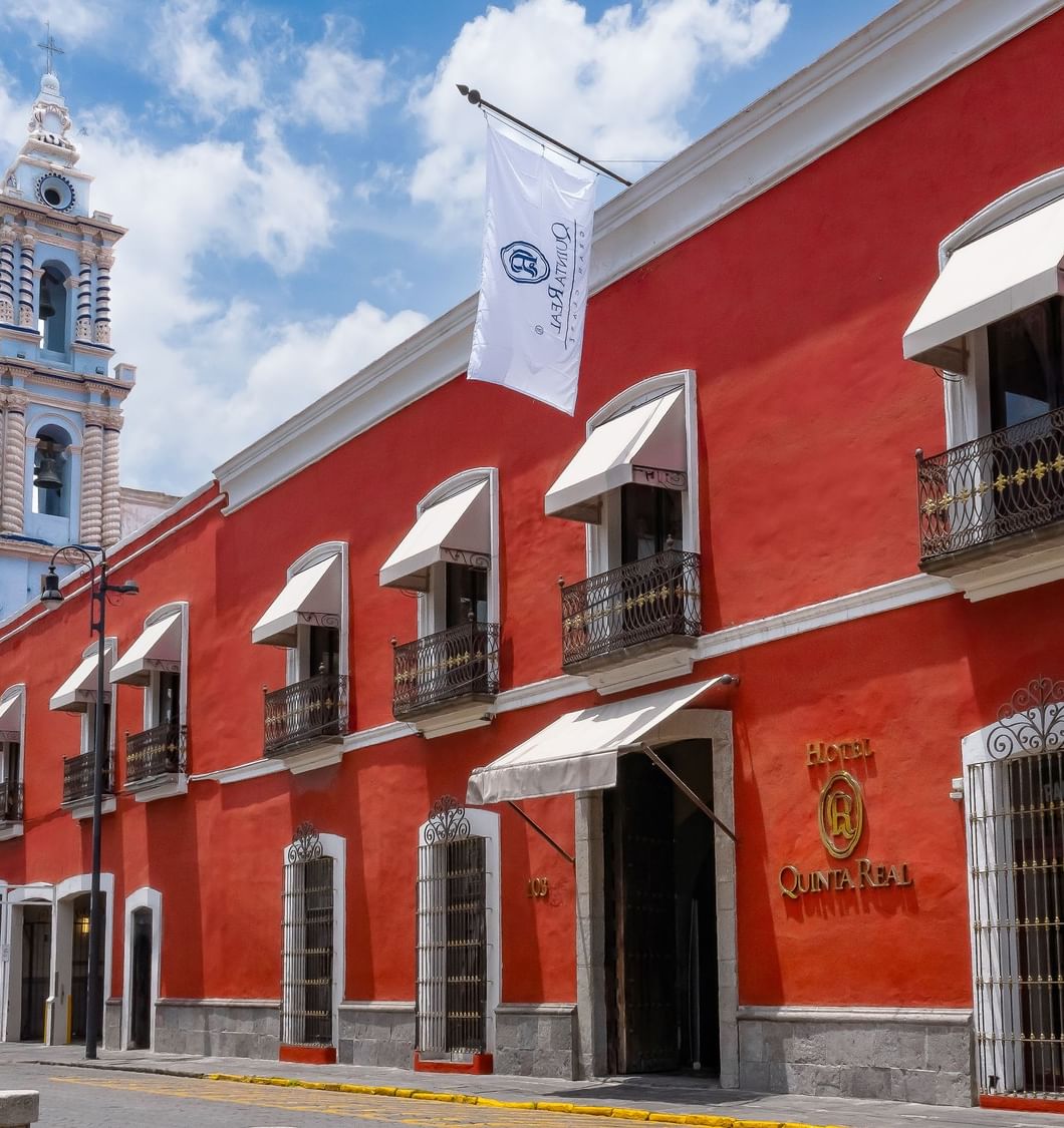 Exterior del hotel Quinta Real junto a histórica catedral azul y blanca en Quinta Real Puebla elegante