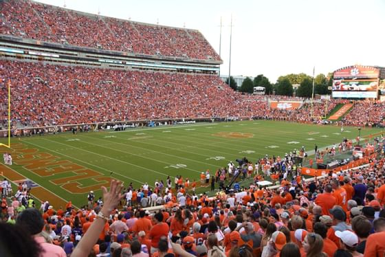 Fans in orange filling stands above the turf at Clemson Memorial Stadium near the Clemson University Conference Center & Inn