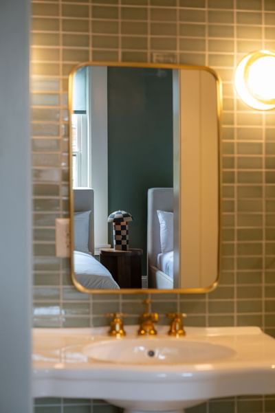 Bathroom vanity with mirror in a room at The Ashbrook Hotel, featuring Frankfort Kentucky lodging