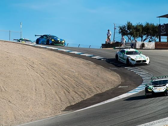 Cars racing at Mazda Raceway Laguna Seca near Tally Ho Inn