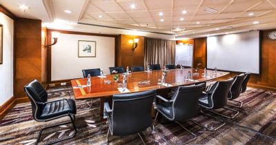 A meeting room with black chairs a wooden table