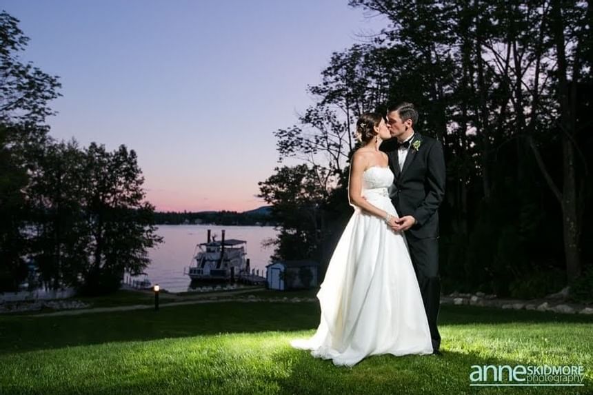 Newlyweds posing by the lake at Wolfeboro Inn