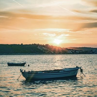 Fishing boats on the sea near Falkensteiner Hotels at sunset