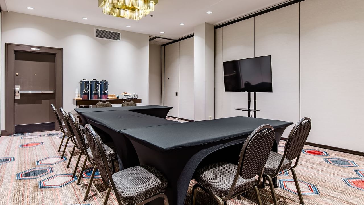 Meeting room with chairs, tables, TV, and refreshments