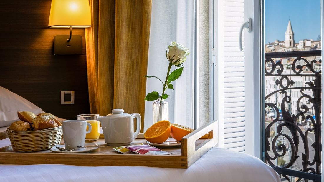 Breakfast platter on bed in Deluxe Room at Oceania Hotels Group