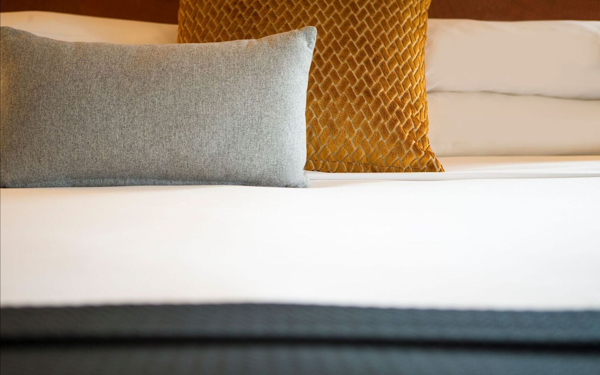 a close-up of a bed with white sheets and two pillows