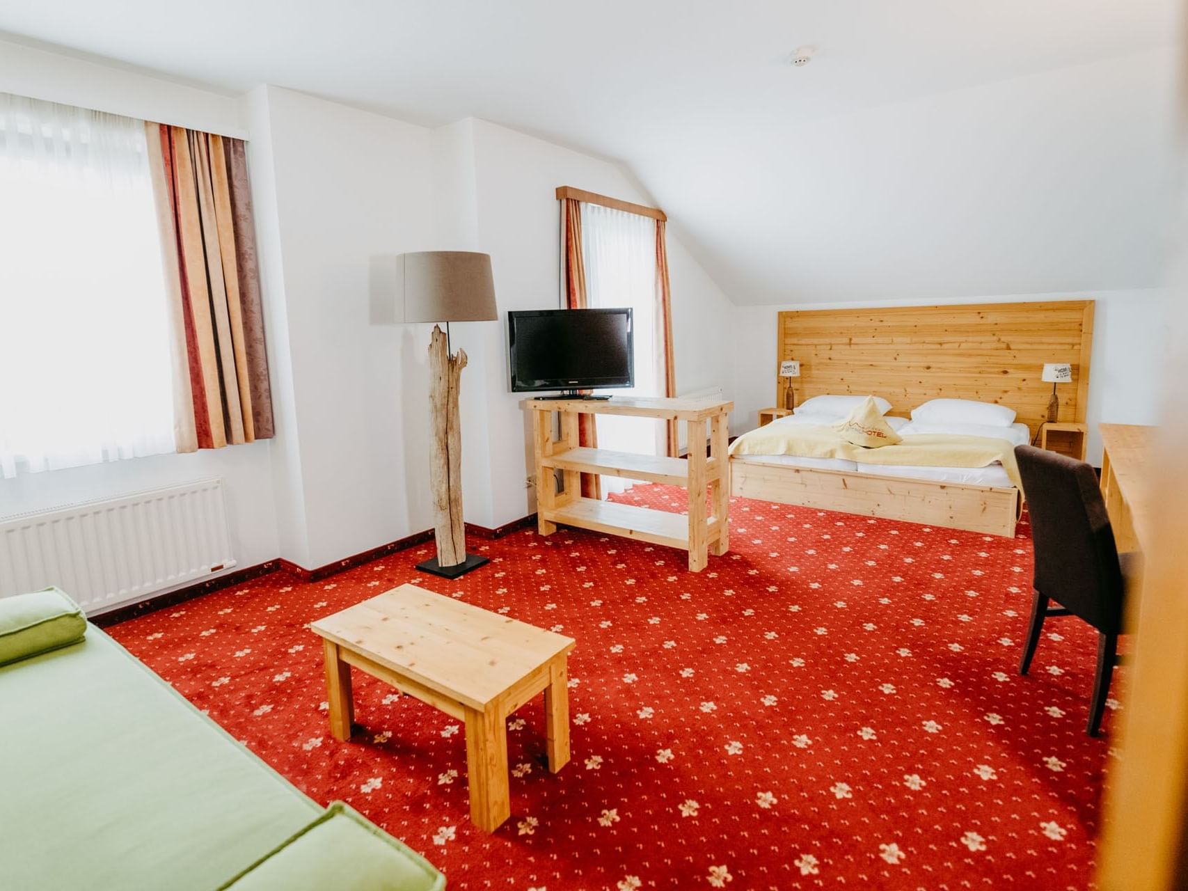 Junior Suite mit Teppich und Sitzgelegenheit.