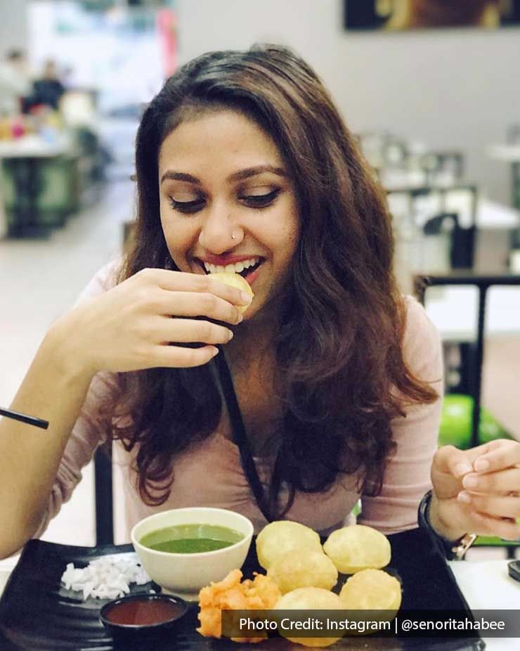 Close-up of a lady enjoying pani-puri in Jalan Alor street food stall near Imperial Lexis Kuala Lumpur