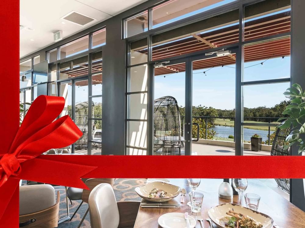 Restaurant interior with set tables overlooking a river at Mercure Kooindah Waters