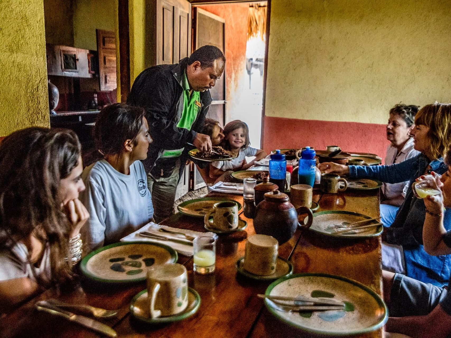 Server serving food to guests under a dining area, cultural experiences in Nicaragua at Morgan's Rock Reserve & Ecolodge