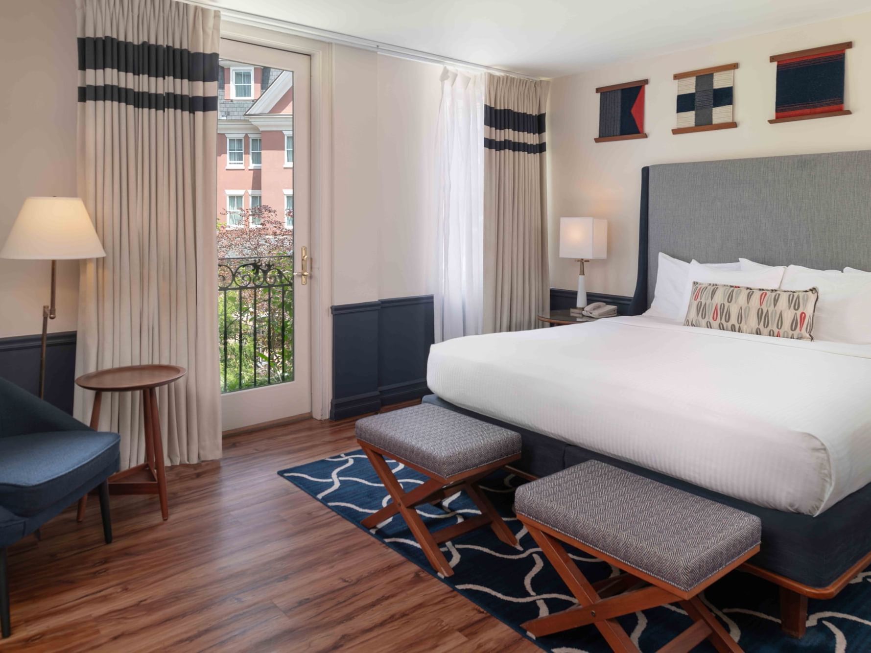 Two ottomans by the bed in Garden View Rooms with wooden floors at Portland Harbor Hotel